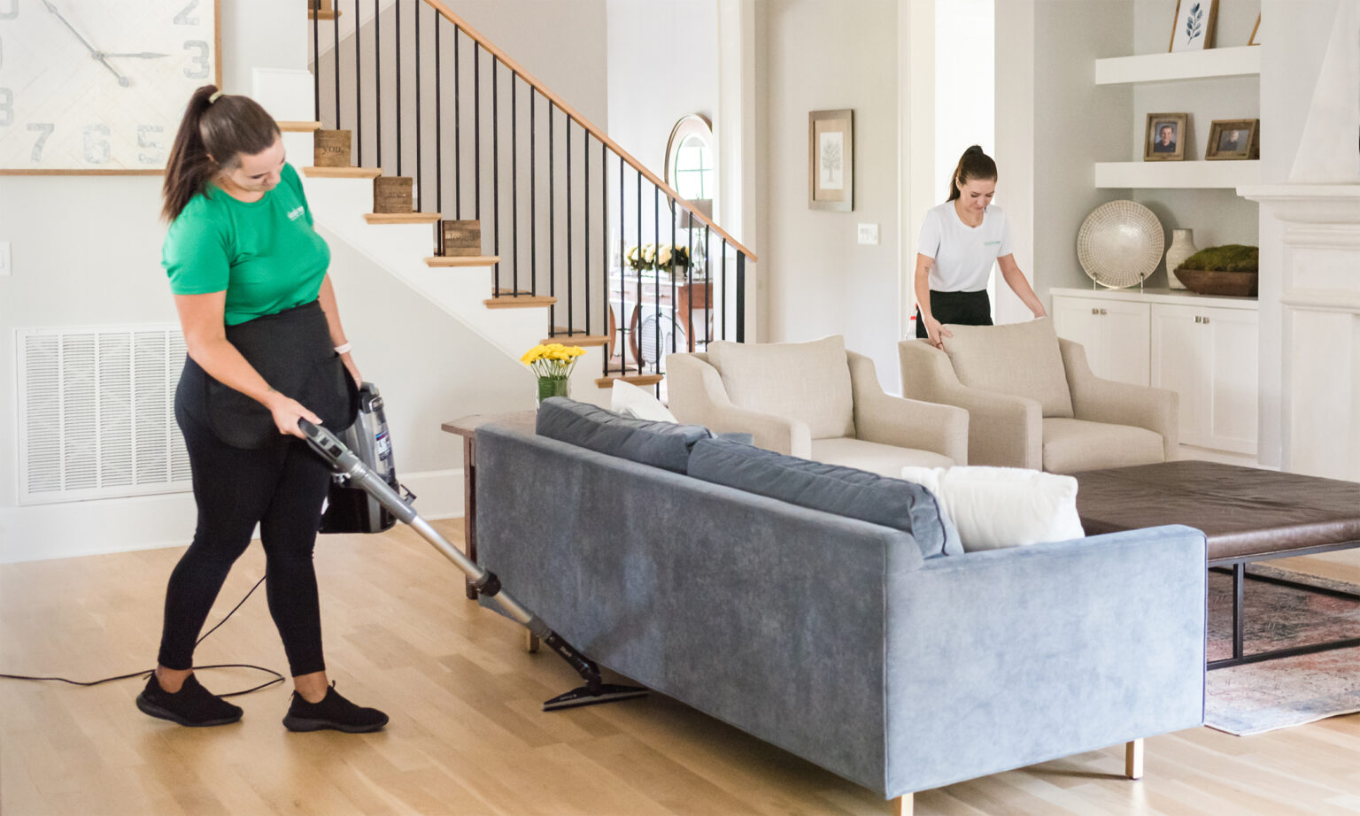 Simply Pure Home team members cleaning and vacuuming family room