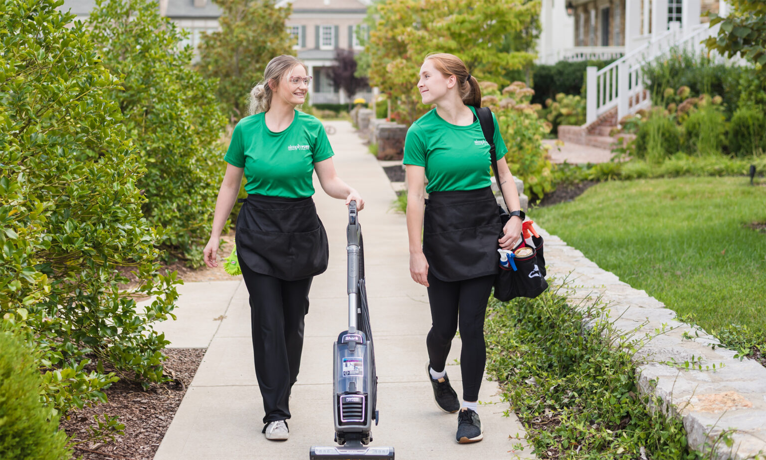 Two cleaning team members walking to job in neighborhood