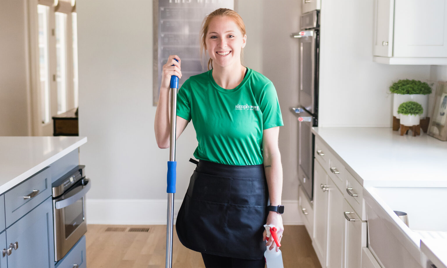 Cleaner standing in kitchen with mop
